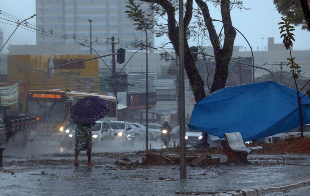 Pedestre e motoristas enfrentam chuva intensa em via do Distrito Federal